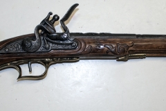 Replica flintlock pistol with carved stock.